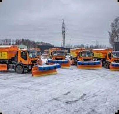 A Group Of Snowplow Trucks Parked In A Parking Lot