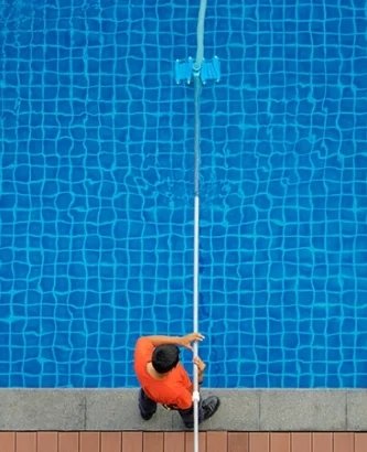 A Person Cleaning a Pool